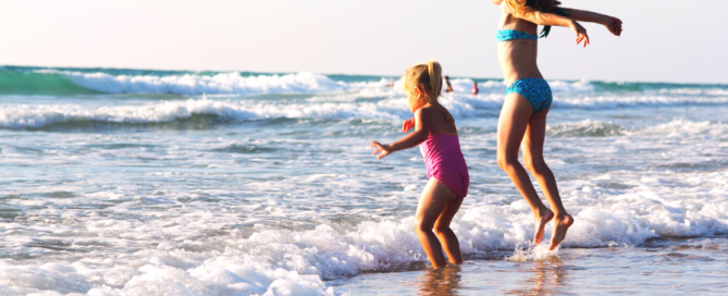girls jumping on the beach having fun